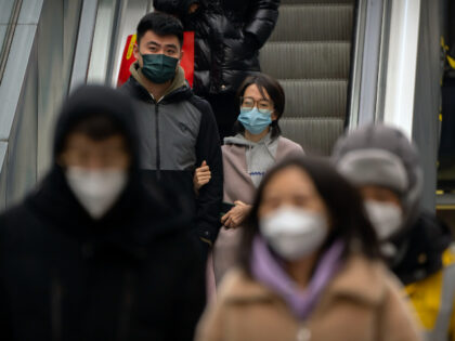 People wearing face masks ride an escalator at a shopping and office complex in Beijing, Wednesday, Jan. 11, 2023. Japan and South Korea on Wednesday defended their border restrictions on travelers from China, with Tokyo criticizing China's move to suspend issuing new visas in both countries as a step unrelated …