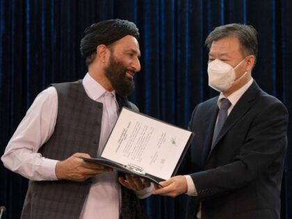 AFGHANISTAN-CHINA-POLITICS Ghulam Ghaws Naseri (L), the acting minister of state for disaster management and humanitarian affairs of Afghanistan and China's ambassador to Afghanistan, Wang Yu, exchange documents during a joint press conference in Kabul on July 5, 2022. (WAKIL KOHSAR/AFP via Getty Images)