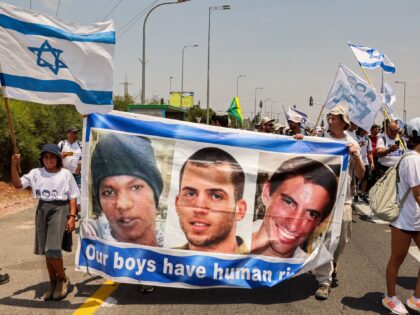 Demonstrators marching with a banner showing the faces of captive Israeli civilian Avera Mengistu, and late soldiers Oron Shaul and Hadar Goldin from the Israeli city of Ashkelon arrive at the Karmia kibbutz on August 5, 2022 in rally called by members of the Goldin family, whose son Hadar was …