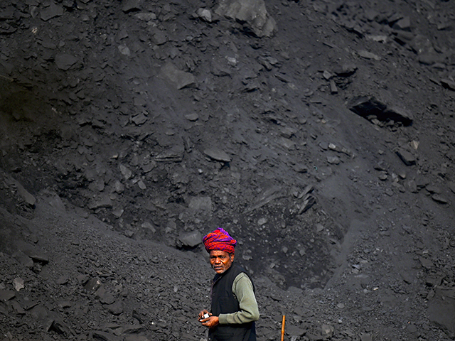 A labourer watches while working in a coal yard at Singrauli in India's Madhya Pradesh sta