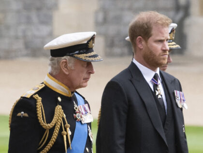 Britain's King Charles III (L) walks with his son Britain's Prince Harry, Duke o