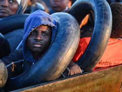 TOPSHOT - Migrants from sub-Saharan Africa sit in a makeshift boat that was being used to clandestinely make its way towards the Italian coast, as they are found by Tunisian authorities about 50 nautical miles in the Mediterranean sea off the coast of Tunisia's central city of Sfax on October …