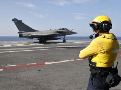 A French navy aircraft handling officer, known as a "Chien Jaune" (French for "yellow dog") watches over as a Rafale aircraft fighter jet taxies on the flight deck of the French aircraft carrier Charles de Gaulle, sailing between the Suez canal and the Red Sea on December 19, 2022. - …