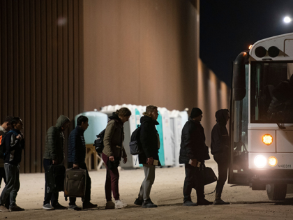 Asylum-seekers board a bus after being processed by US Customs and Border Patrol agents at a gap in the US-Mexico border fence near Somerton, Arizona, on December 26, 2022. - The United States is seeing a rising number of asylum-seekers turning themselves in at the US-Mexico border in anticipation of …