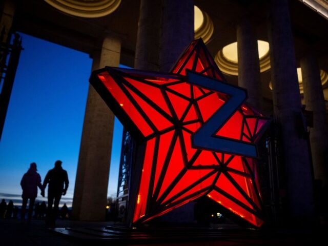 Pedestrians walk past a New Year decoration stylised as the "Kremlin Star", bear