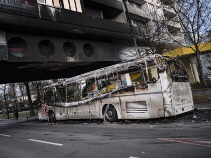 03 January 2023, Berlin: A burned-out tour bus stands in front of a damaged apartment building in the Neukölln district of Berlin after riots on New Year's Eve. Photo: Fabian Sommer/dpa (Photo by Fabian Sommer/picture alliance via Getty Images)