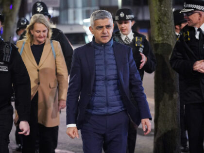Mayor of London Sadiq Khan is accompanied by police officers on a walkabout during a visit