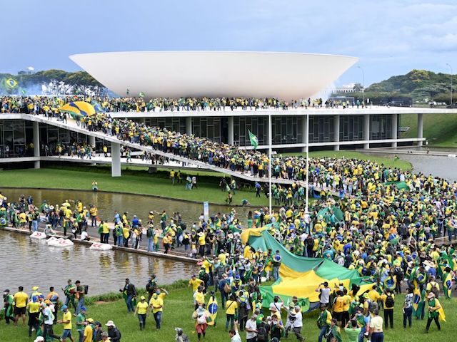 Supporters of Brazilian former President Jair Bolsonaro hold a demonstration at the Esplanada dos Ministerios in Brasilia on January 8, 2023. - Hundreds of supporters of Brazil's far-right ex-president Jair Bolsonaro broke through police barricades and stormed into Congress, the presidential palace and the Supreme Court Sunday, in a dramatic …