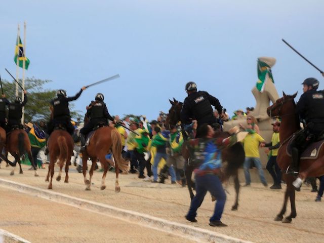 Supporters of Brazilian former President Jair Bolsonaro clash with riot police as they invade Planalto Presidential Palace in Brasilia on January 8, 2023. - Hundreds of supporters of Brazil's far-right ex-president Jair Bolsonaro broke through police barricades and stormed into Congress, the presidential palace and the Supreme Court Sunday, in a dramatic protest against President Luiz Inacio Lula da Silva's inauguration last week. (Photo by Sergio Lima / AFP) (Photo by SERGIO LIMA/AFP via Getty Images)
