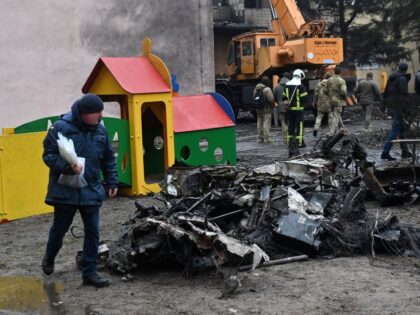 TOPSHOT - Firefighters work near the site where a helicopter crashed near a kindergarten in Brovary, outside the capital Kyiv, killing Sixteen people, including two children and Ukrainian interior minister, on January 18, 2023, amid the Russian invasion of Ukraine. (Photo by Sergei Supinsky / AFP) (Photo by SERGEI SUPINSKY/AFP …