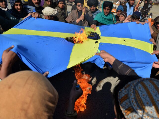 TOPSHOT - Protesters burn a flag of Sweden during a demonstration against the burning of the Koran by Swedish-Danish far-right politician Rasmus Paludan, in Kandahar on January 25, 2023. (Photo by Sanaullah SEIAM / AFP) (Photo by SANAULLAH SEIAM/AFP via Getty Images)