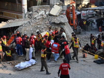 Rescue workers carry the remains of the blast victims from the debris of a damaged mosque