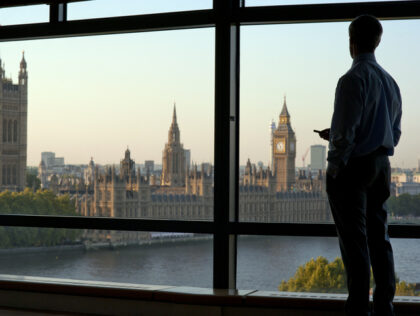 Businessman looking down at Houses of Parliament and River Thames