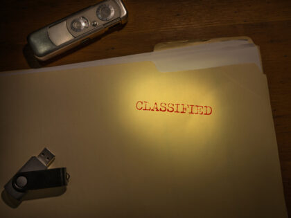 Folder marked Classified with spy camera and thumb drive
