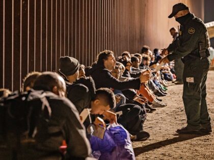 YUMA, ARIZONA - DECEMBER 30: A U.S. Border Patrol agent checks for identification of immigrants as they wait to be processed by the U.S. Border Patrol after crossing the border from Mexico on December 30, 2022 in Yuma, Arizona. (Photo by Qian Weizhong/VCG via Getty Images)