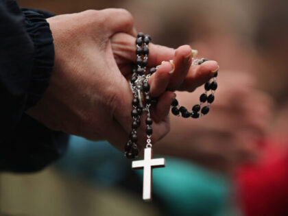 VATICAN CITY, VATICAN - MARCH 13: A woman holds rosary beads while she prays and waits for
