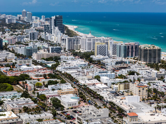 Aerial view looking East over ocean of South Beach Miami Florida cityscape with buildings along the beach on a beautiful sunny day