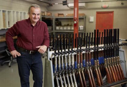 Henry Repeating Arms Founder and CEO Anthony Imperato poses with a rack of finished lever action rifles in the company’s Bayonne, New Jersey facility. (henryusa.com)