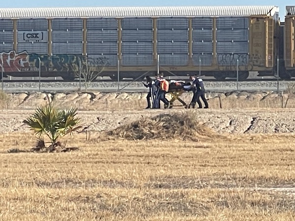 Rescue workers carry one dehydrated migrant from the railcar to the awaiting helicopter. (Randy Clark/Breitbart Texas)
