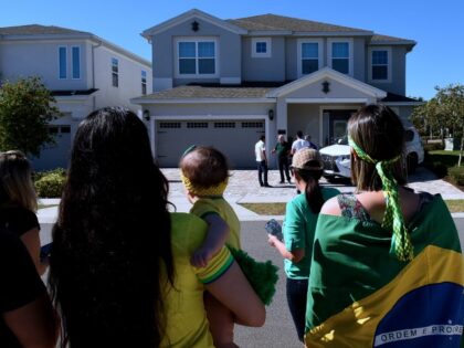KISSIMMEE, FLORIDA, UNITED STATES - JANUARY 11: Supporters of former Brazilian far-right President Jair Bolsonaro stand in front of the home he is staying in, hoping he will emerge, at Encore resort at Reunion on January 12, 2023 in Kissimmee, Florida. Bolsonaro has been living in the gated community since …