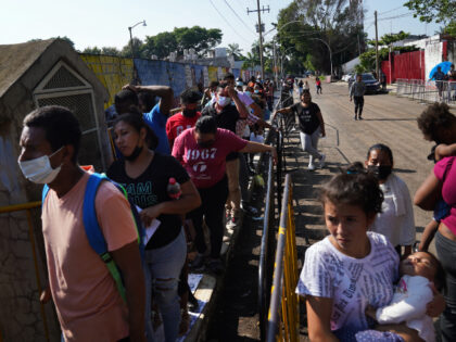 Migrants wait in line for their turn to apply for legal migration documents outside the National Immigration Institute in Tapachula, Chiapas state, Mexico, Tuesday, Oct. 4, 2022. Migrants use “safe passage” permits _ the common term for some of the temporary documents issued by the Mexican government. Most allow the …