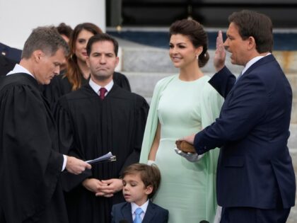 Florida Gov. Ron DeSantis, right, is sworn by Florida Supreme Court Chief Justice Carlos Muniz, left, to begin his second term during an inauguration ceremony outside the Old Capitol Tuesday, Jan. 3, 2023, in Tallahassee, Fla. Looking on is DeSantis' wife, Casey, second from right, and their son, Mason. (AP …