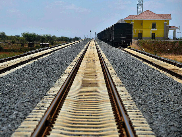 A cargo cars carrying ballast stands on the tracks at an bogie-exchange along a section of