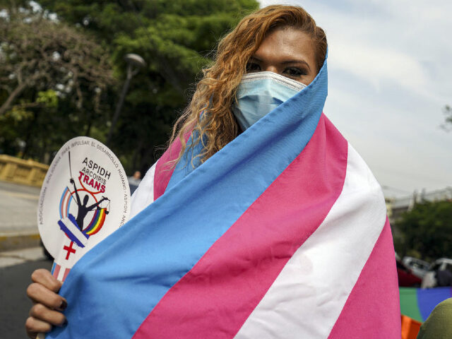 SAN SALVADOR, EL SALVADOR - 2022/05/17: A transgender woman draped in a transgender flag d