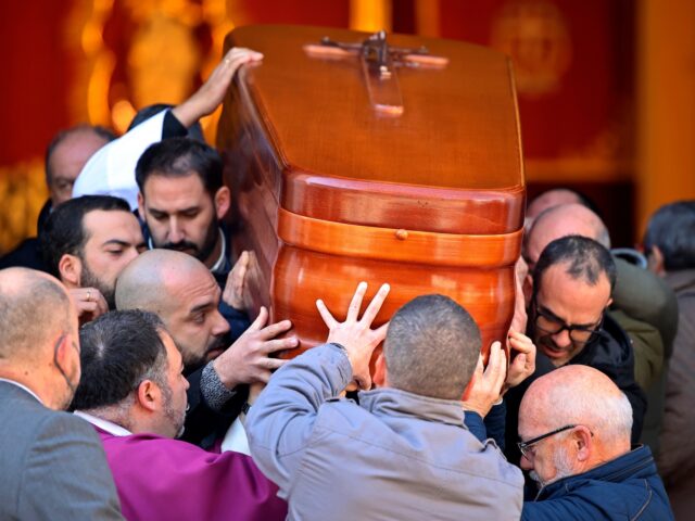 The coffin of the church sacristan who was attacked and killed Wednesday is carried out of