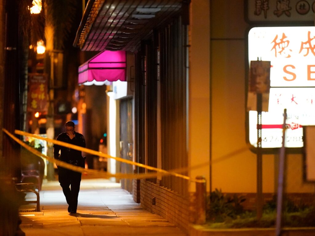 A police officer walks near a scene where a shooting took place in Monterey Park, Calif., Sunday, Jan. 22, 2023. Nine people were killed in a mass shooting late Saturday in a city east of Los Angeles following a Lunar New Year celebration that attracted thousands, police said. (AP Photo/Jae C. Hong)
