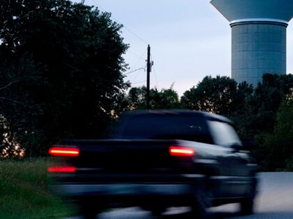 FILE - A truck drives down a rural road near a water tower marking the location of the Mem
