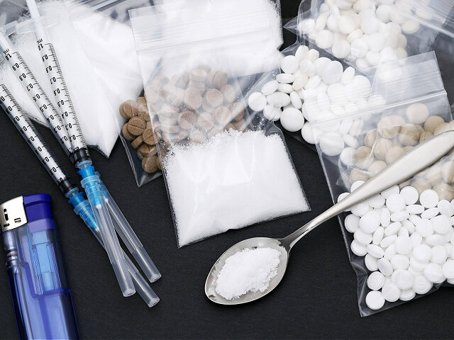 Cooked heroin drugs and injection syringe - stock photo