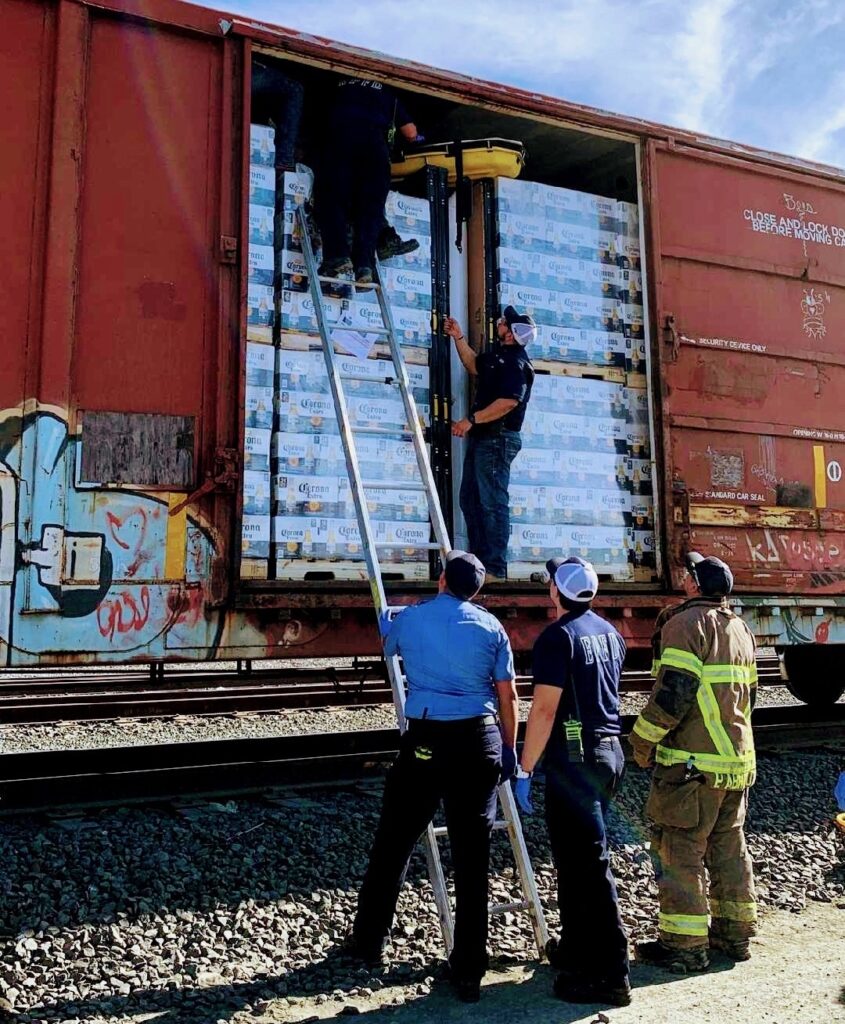 A dehydrated migrant is removed from a locked rail car that crossed the border from Mexico. (Law Enforcement Photo)