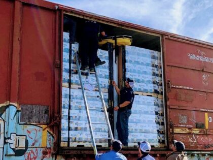 A dehydrated migrant is removed from a locked rail car that crossed the border from Mexico. (Law Enforcement Photo)
