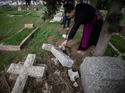 JERUSALEM - JANUARY 04: Husam Naum, Anglican Archbishop of Jerusalem examines graves damaged by Jewish settlers who sneaked into the Protestant cemetery on Mount Sion in East Jerusalem on Sunday, January 1 in Jerusalem on January 04, 2023. Jewish settlers damaged more than thirty tombs. (Photo by Mostafa Alkharouf/Anadolu Agency …