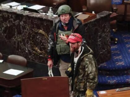 Joshua Black on the Senate Floor on January 6, 2021, wearing a red hat, camouflaged pants, and yellow gloves. (Justice Department
