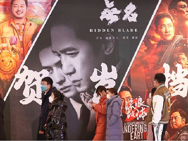 TAIYUAN, CHINA - JANUARY 22: People walk by posters of films 'Hidden Blade' and 'The Wandering Earth 2' at a cinema on January 22, 2023 in Taiyuan, Shanxi Province of China. The Chinese Lunar New Year, or Spring Festival, falls on January 22. (Photo by Zhang Yun/China News Service/VCG via …