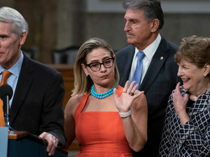 Sen. Kyrsten Sinema, D-Ariz., center, gestures during a news conference at the Capitol in Washington, Wednesday, July 28, 2021, while working on a bipartisan infrastructure bill with, from left, Sen. Rob Portman, R-Ohio, Sen. Joe Manchin, D-W.Va., and Sen. Jeanne Shaheen, D-N.H. Though elected as a Democrat, Sinema announced Friday, …