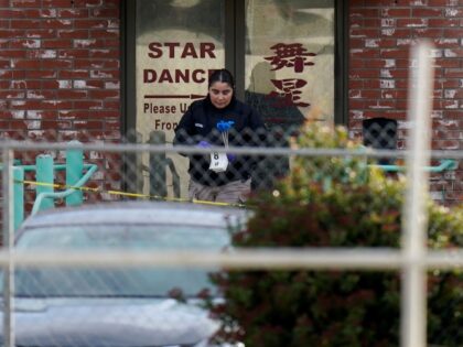 An investigator carries markers outside Star Dance Studio in Monterey Park, Calif., Sunday, Jan. 22, 2023. A mass shooting took place at the dance club following a Lunar New Year celebration, setting off a manhunt. (AP Photo/Jae C. Hong)