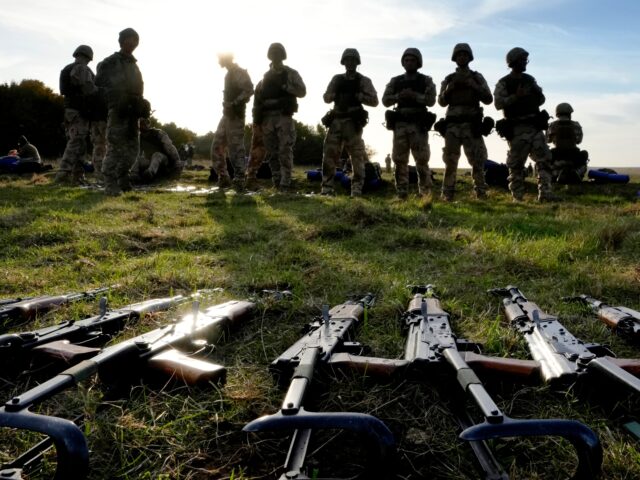 FILE - Weapons lie on the ground as Ukrainian personnel take a break during training at a