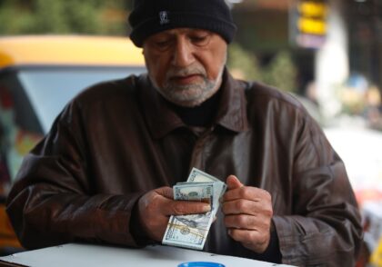 A man counts US dollar banknotes in a Baghdad market on December 27, 2022 as the value of