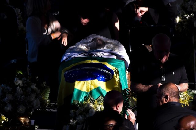 A flags of Brazil and Santos were draped across the coffin of Brazilian football legend Pe