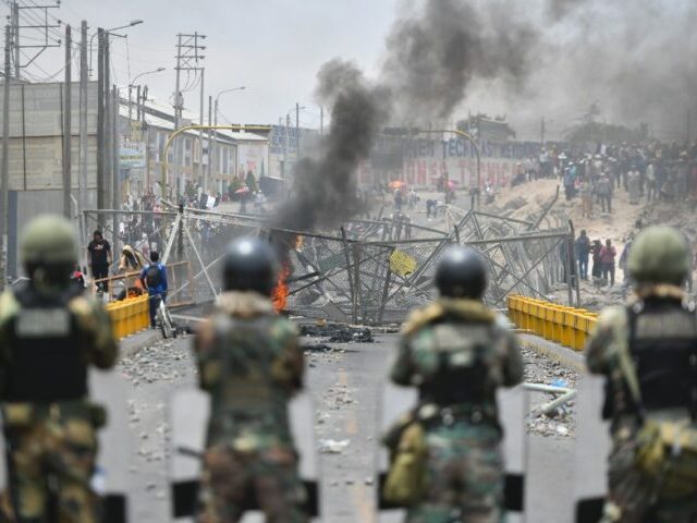 Members of the Peruvian security forces face off with protesters on a bridge near the airp