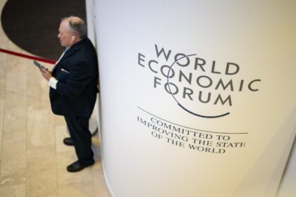 A participant uses his mobile phone at the Congress centre during the World Economic Forum