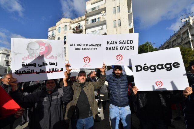 Tunisian demonstrators raise protest placards calling on the president to step down as the