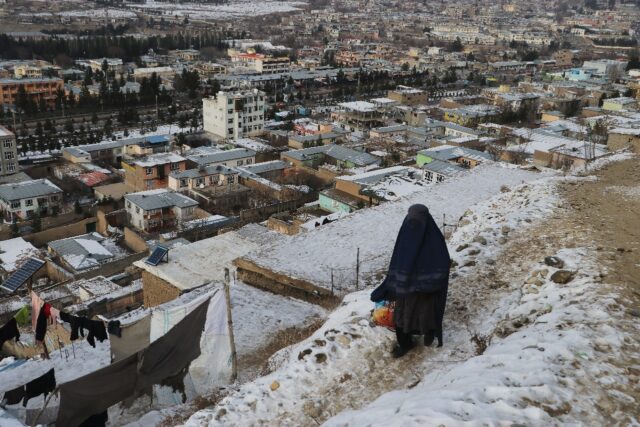 A woman walks down at a path during a cold winter day in Fayzabad of Badakhshan province i