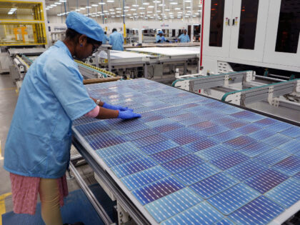 A worker makes arrangements of solar cells at Premier Energies Solar on the outskirts of Hyderabad, India, Wednesday, Jan. 25, 2023. (AP Photo/Mahesh Kumar A.)