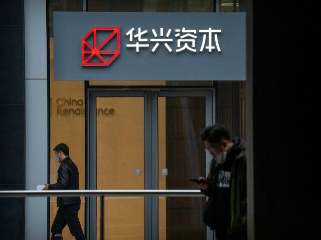 People walk past a China Renaissance office at an office building in Beijing, Friday, Feb.