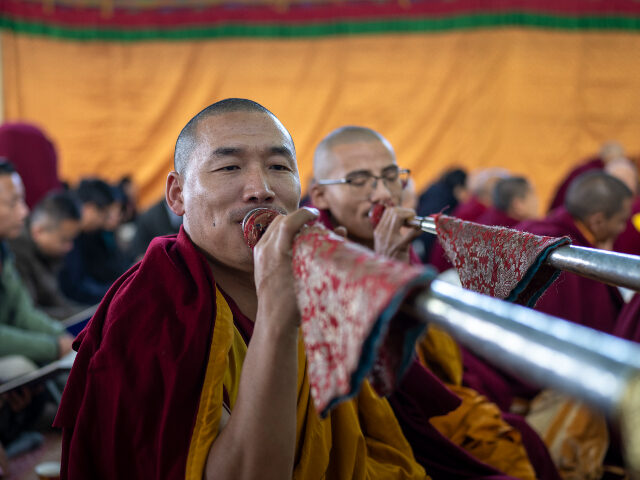 Exile Tibetan Buddhist monks blow ceremonial horns during an early morning prayer session