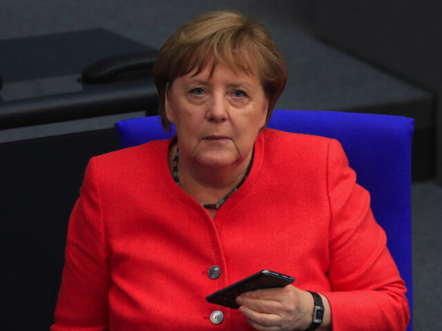 Angela Merkel, Germany's chancellor, holds a smartphone in the Bundestag as Germany t